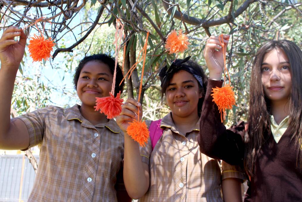 2014: Mallen Matenga, Sally Tawa and Emily Nehme yarn bomb a tree at Wade High School in honour of Harmony Day.