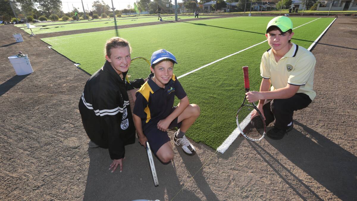 2014: Alison Triggs, 13, Ben Mahlknecht, 11, and Jaidyn Dickie, 15, admire the new surfaces that were laid this week at the Griffith Tennis Club's Jack Shannon complex. Picture: Anthony Stipo