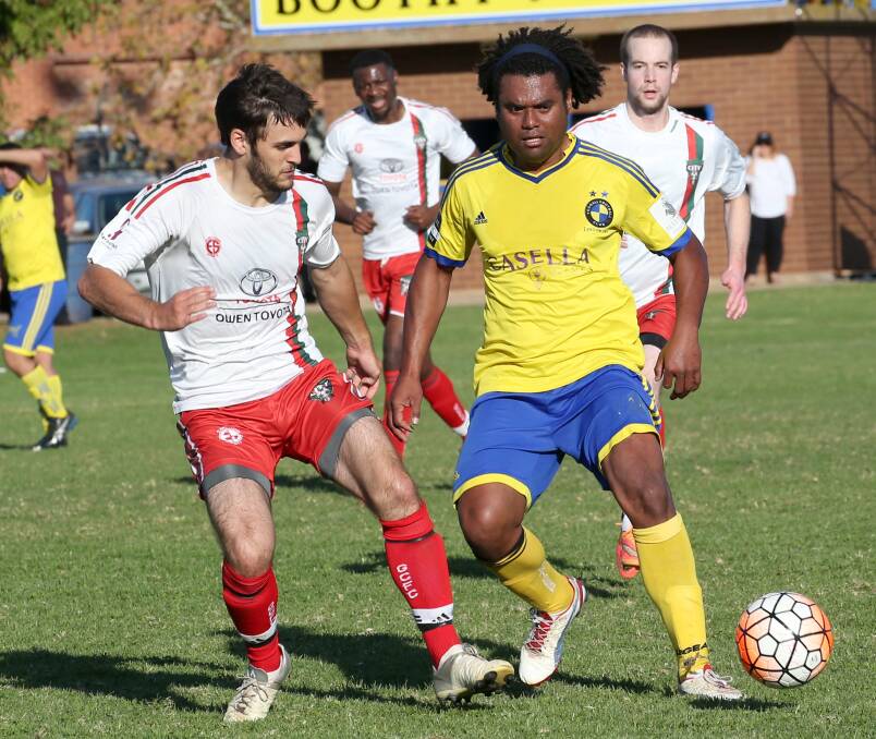 CONTROL: Yoogali FC's Tuimasi Manuca passes as Griffith City's Joshua Jackson closes in. 
Picture: Anthony Stipo