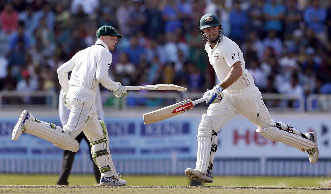 AGAINST THE ODDS: Peter Handscomb and Shaun Marsh run between the wickets during the fifth day of the third Test match against India in Ranchi. PHOTO: AP Photo/Aijaz Rahi