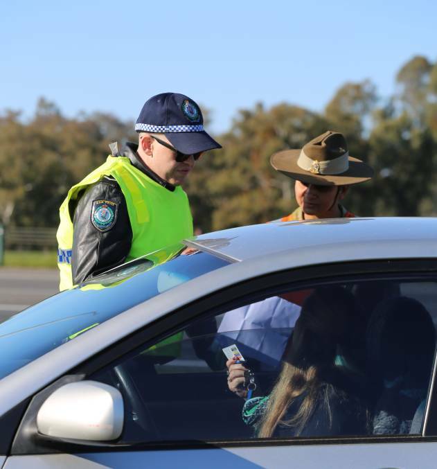 WATCHING: Soldiers and police check cars. Picture: NSW Police
