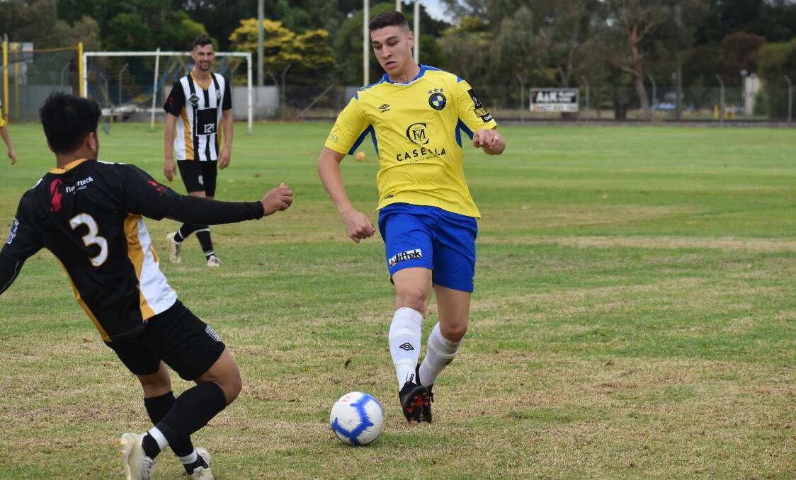 BACK ON THE PARK: Yoogali FC's Joseph Poli looks to knock the ball around a West Griffith defender during a trial game recently. PHOTO: Liam Warren