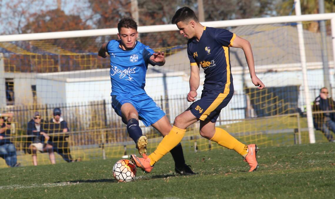 CLOSER BATTLES: Hanwood FC's Tyler Andreazza looks to keep the ball away from Yoogali SC Isaac Donadel during last season's grand final. Picture: Anthony Stipo