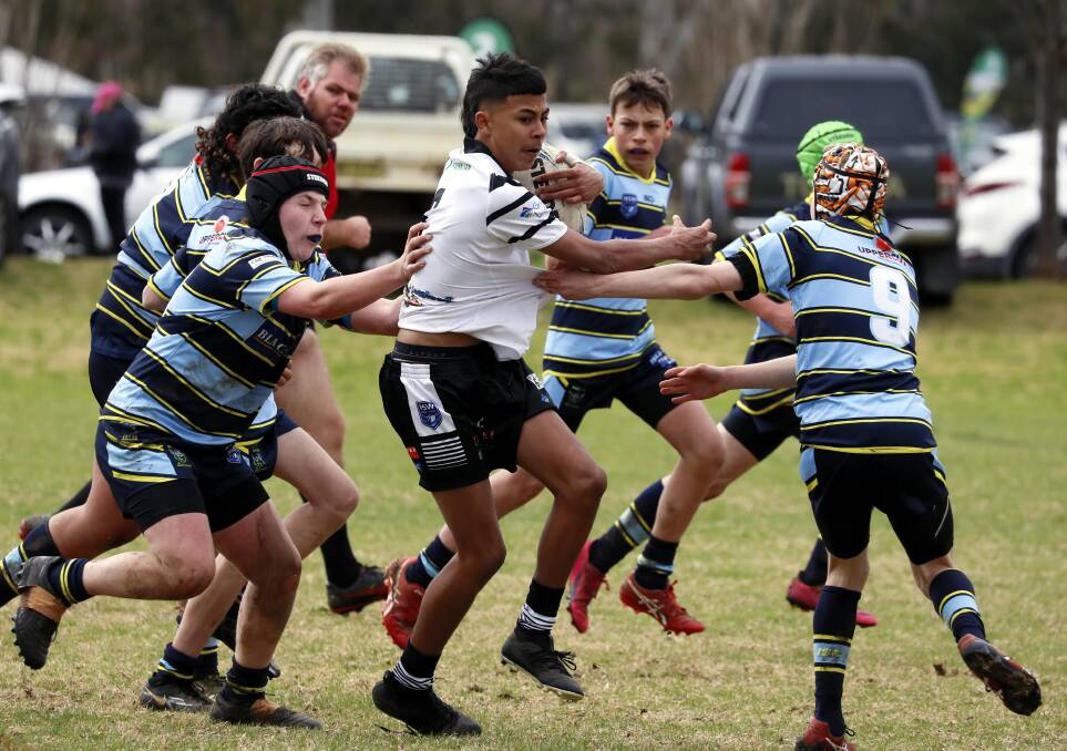 IN TRAFFIC: Griffith Black & Whites' Vinnie Taylor tries to break out of the West Belconnen defence in the Riverina Schoolboys Carnival at Junee on Saturday. PHOTO: Les Smith