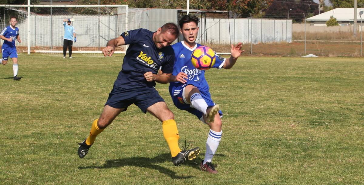 FIGHTING HARD: Yoogali SC's Mark Giammini contests possession with Brad Plos from Hanwood Blue last weekend. PHOTO: Anthony Stipo