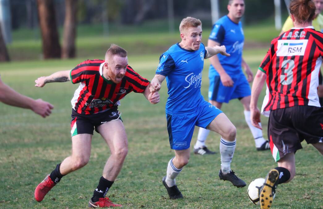 GETTING OUT: Hanwood's Andy Gamble looks to break away from the Lake Albert defence during the side's meeting earlier in the season. PHOTO: Emma Hillier