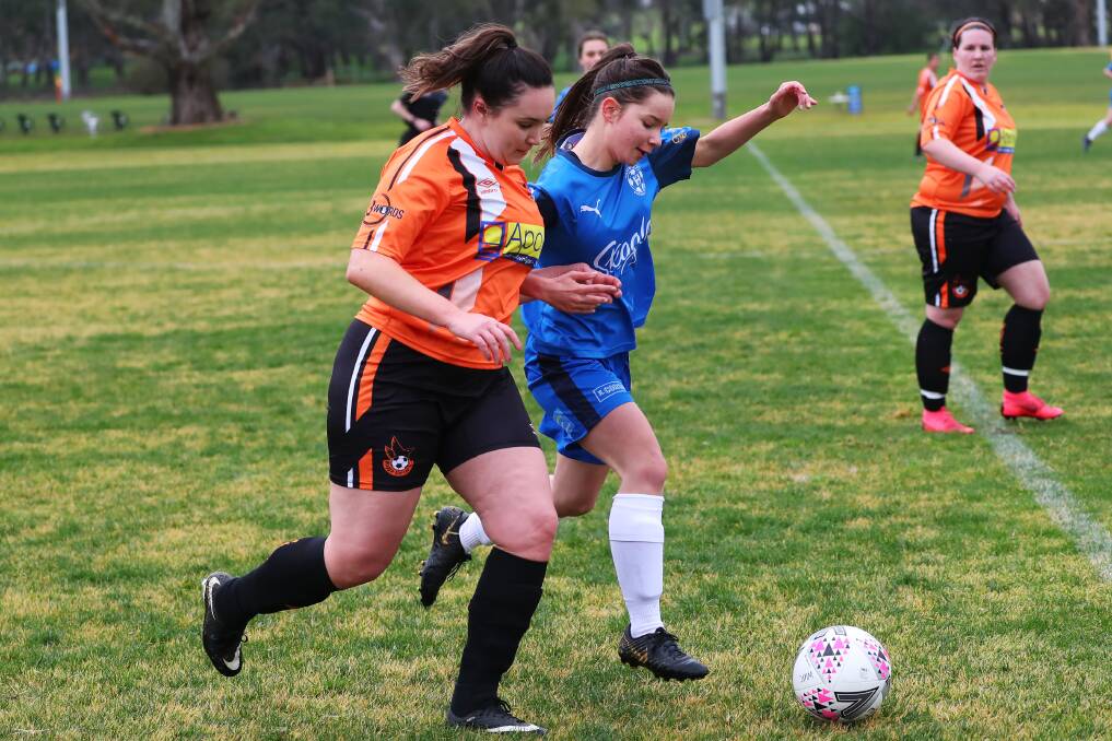 SHOULDER TO SHOULDER: Hanwood's Jemimah Brooker and Wagga United's Bronte Langbroek battle for possession during Hanwood's convicing win. PHOTO: Emma Hillier