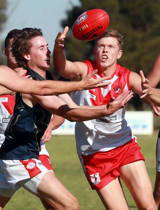 Riley Irvin looks to pull the ball into his possession during clash with Demons