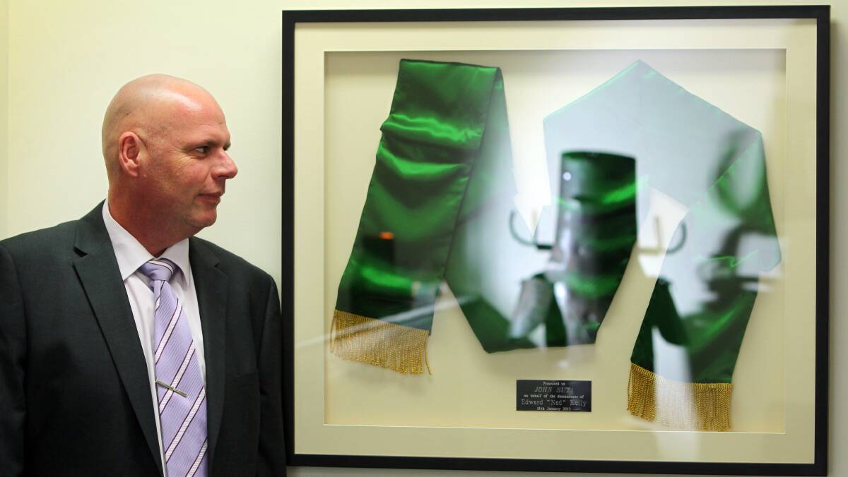 Trinket: John Suta with a replica of the green sash Ned Kelly received for saving a boy from drowning.
