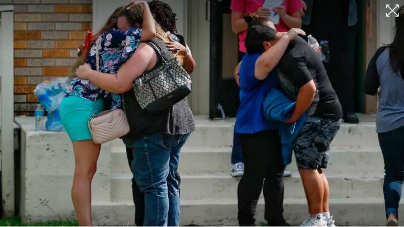 Parents and students embrace outside a gym where students had waited to be reunited with their families. Photo: Houston Chronicle