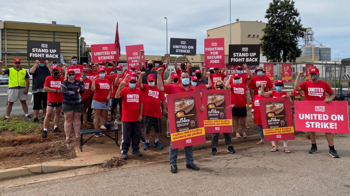 STAND TOGETHER: SunRice frontline staff with Tom Czech from the United Workers Union (front, middle) outside their workplace during day one of strike action. PHOTO: Talia Pattison 