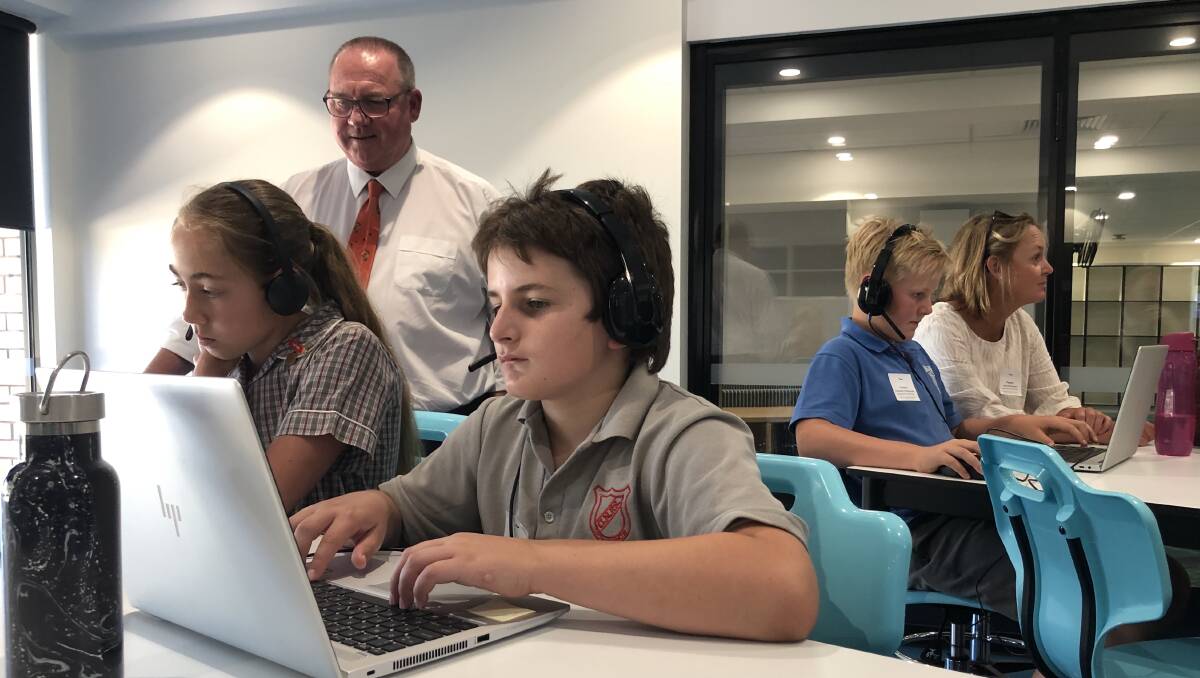FOCUS: Emma King and Kurt Roberts from Griffith North Public School knuckle down under the watchful gaze of Murrumbidgee High principal David Crelley. In the background, Tharbogang Public School's Fletcher Robertson concentrates next to his mother Julie Robertson. PHOTO: Monty Jacka