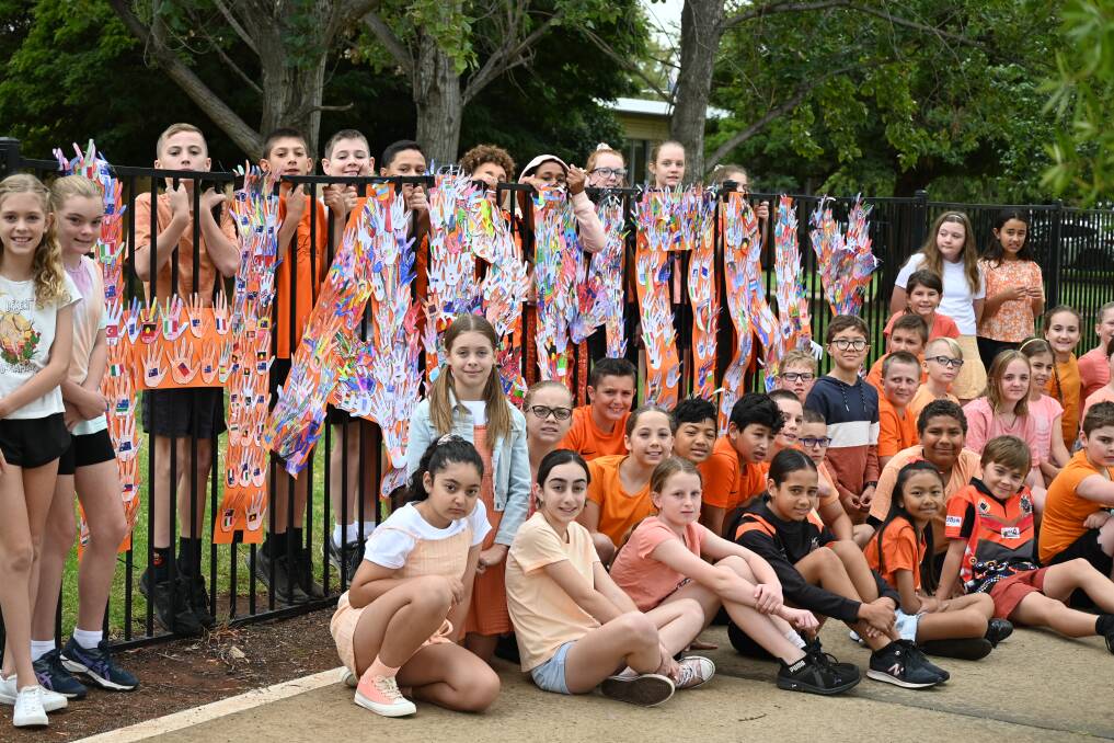 Griffith East Public School students with the 'Harmony' hand artwork. Photo: Supplied.