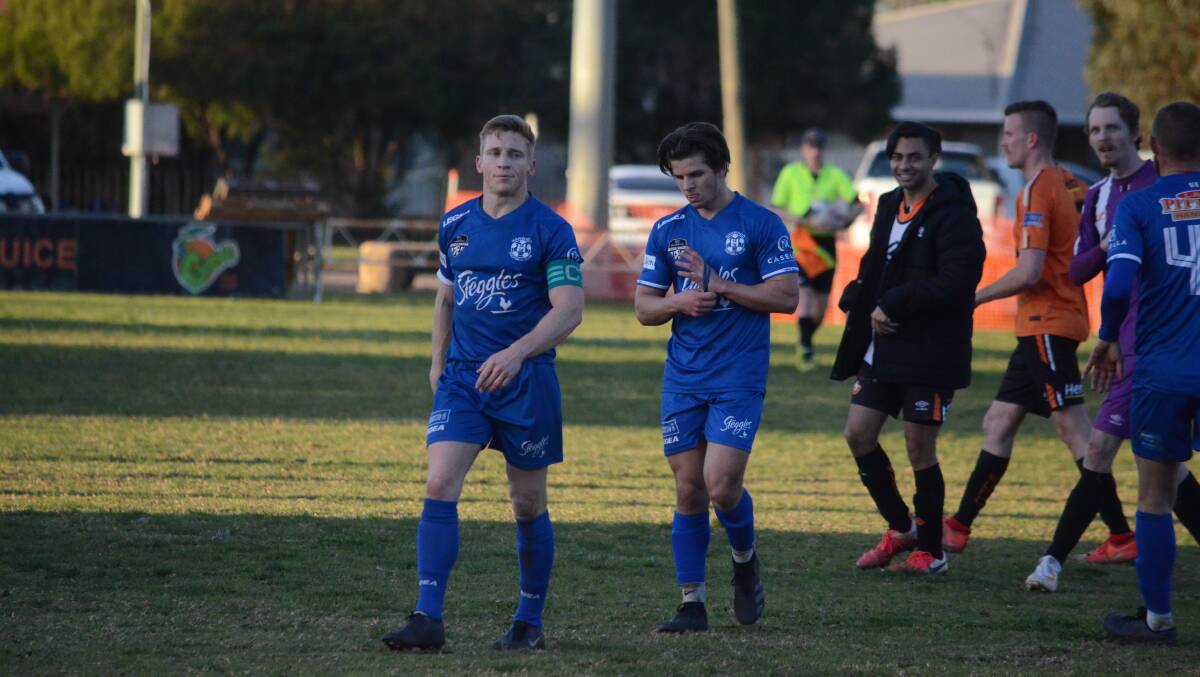 RUN OVER: Hanwood FC's Andy Gamble and Jordan Austin walk off the field disappointed after dropping their first points of the season against Wagga United. PHOTO: Monty Jacka