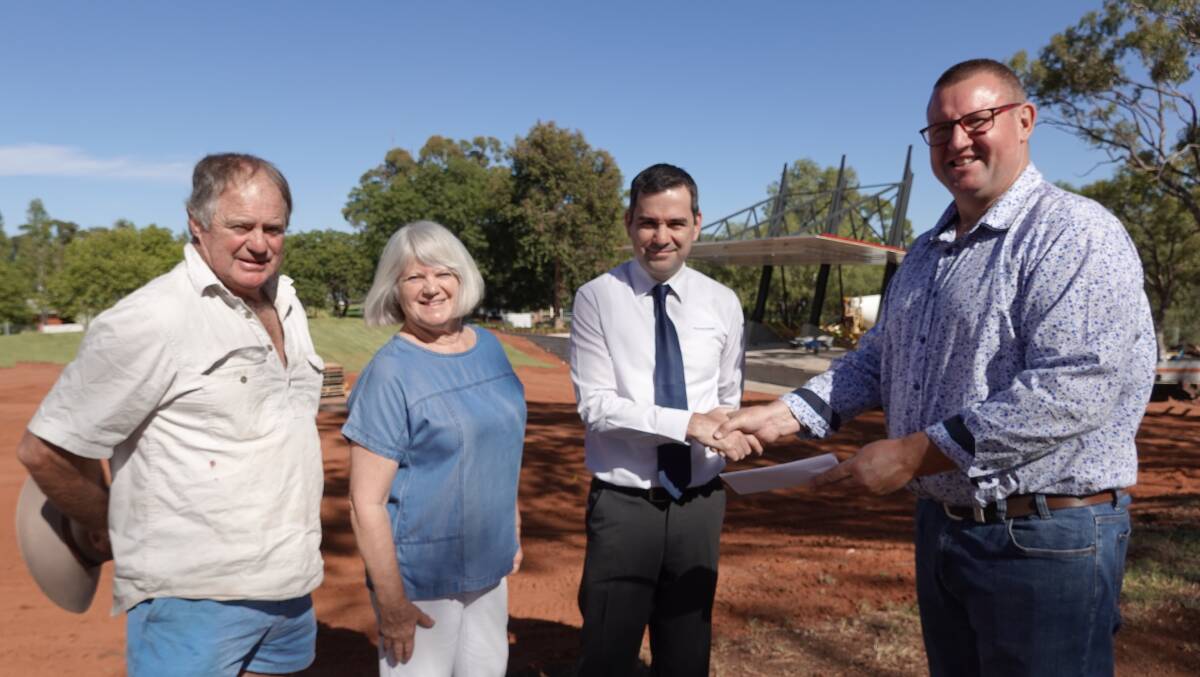 FINAL GIFT: La Festa committee members Brian Dossetor, Leith Fry, and John Farronato hand over the donation to Griffith City Council's Doug Curran in front of the stage. Photo: Monty Jacka