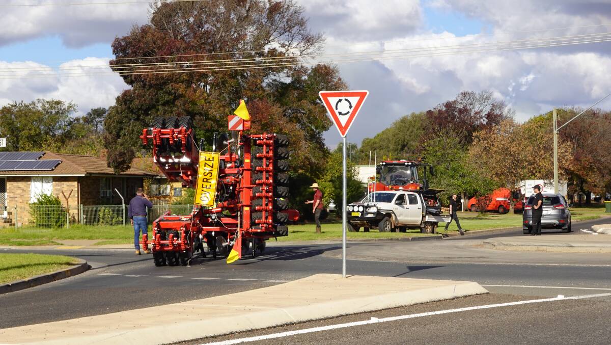 STUCK: The seeder came unhooked and tipped over while crossing the Willandra Avenue and Ulong Street roundabout by Murrumbidgee Regional High School. PHOTO: Monty Jacka