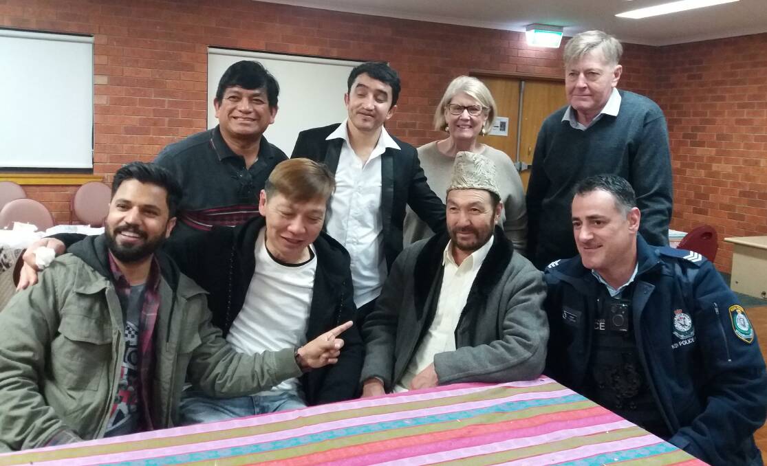 TOGETHER: Rey Reynaldo, Noorullah Hassani, Patricia Clarke and John Delves (back row) alongside Zeshun, Yappoi Min, Anwar Hussain and Paul Rosano (front row) at the Centacare Refugee Week dinner. PHOTO: Contributed