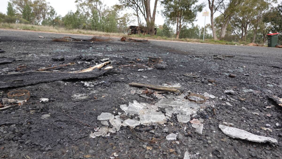 DESTROYED: Shattered glass and charred pieces of metal are scattered across the Scenic Drive carpark where the Holden Commodore was found blazing. PHOTO: Monty Jacka