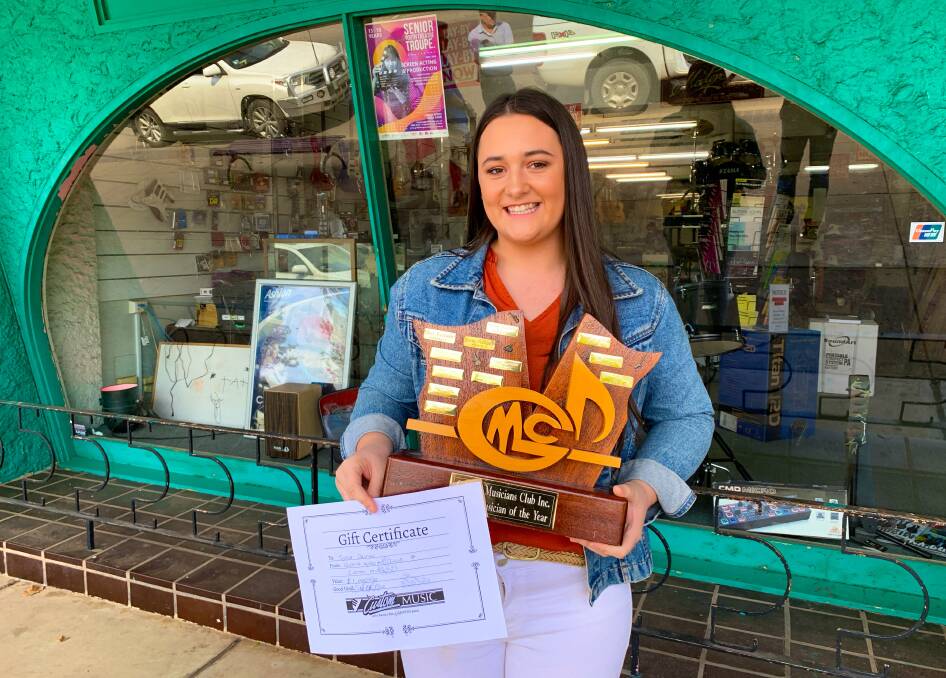 WINNER: Hillston's Jorja Dalton celebrates taking out the Griffith Musicians Club Young Musician of the Year award in a unique ceremony outside of Custom Music on Saturday. PHOTO: Contributed