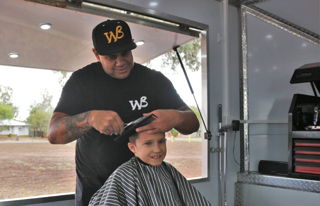 FRESH CUT: 'Walkabout Barber' Brian Dowd provides Waylan Lucas with a new hair style during his visit to the city on Monday. PHOTO: Calhan Behrendt