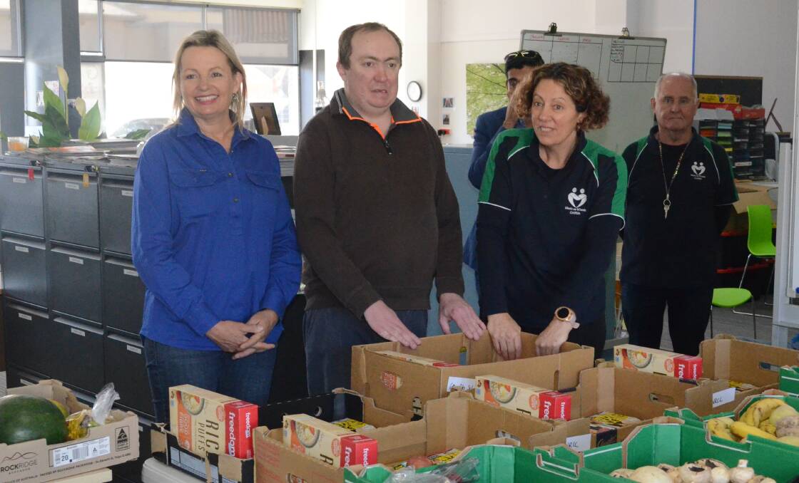 TAKING STOCK: Member for Farrer Sussan Ley talks with Meals on Wheels volunteers about the Hampers of Hope program. PHOTO: Calhan Behrendt