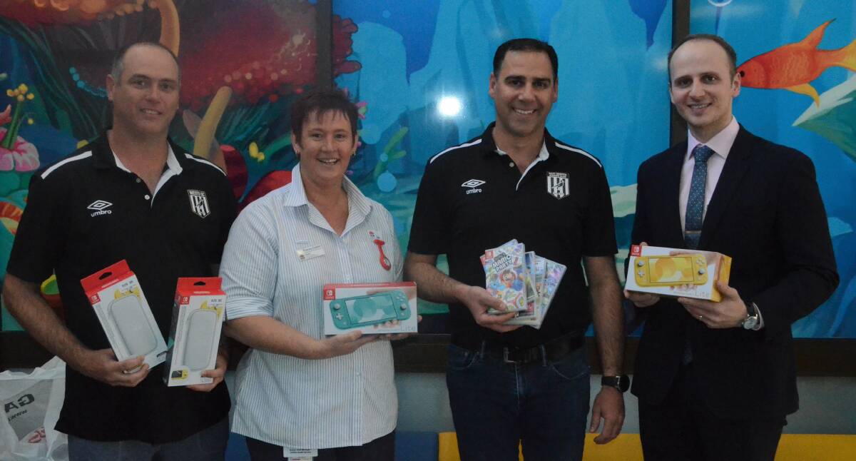 SWITCHING ON: West Griffith SC Vice President Shanyn Catanzariti (left) and President Donovan Colpo (middle right) donate a pair of Nintendo Switches to nursing unit manager Tracey Costin and Griffith Base Hospital GM Greg Brylski. PHOTO: Calhan Behrendt