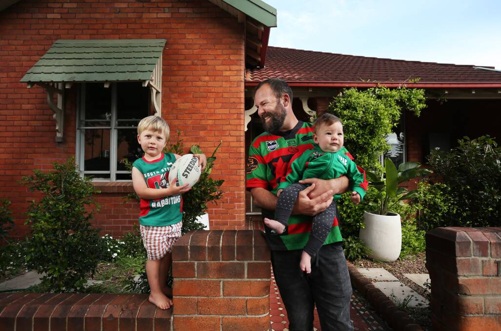 WE CAN DO IT: South Sydney Rabbitohs supporter Callan Lawrence, outside his Hamilton home with sons Ezra, aged 3, and Mark, 7 months ahead of Sunday night's NRL grand final in Brisbane. Picture: Simone De Peak