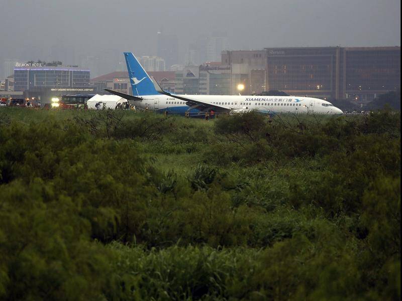 A passenger plane lies on the grassy portion of the runway of the airport, in Manila, Philippines.