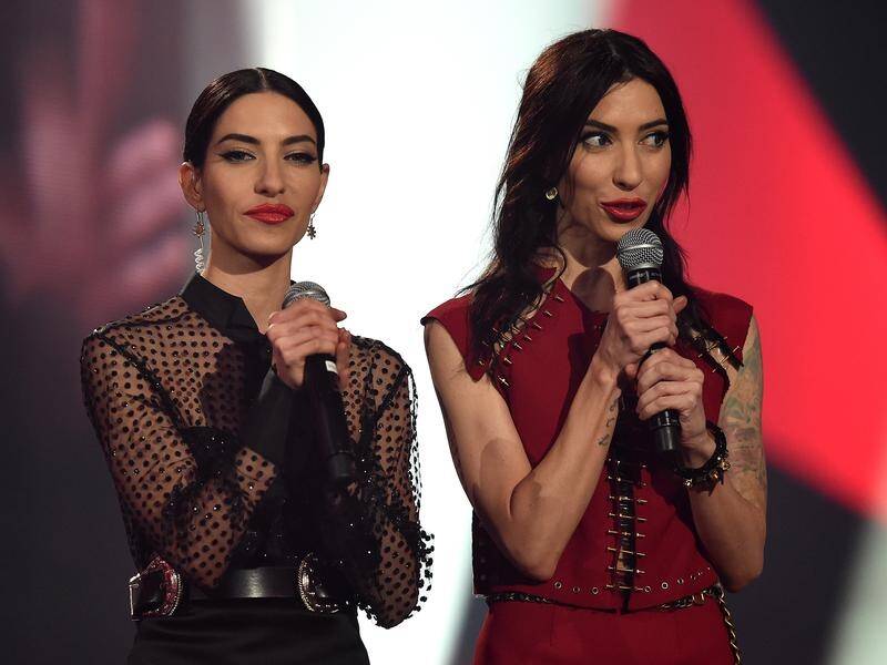 The Veronicas are threatening legal action against Qantas after being asked to leave a plane.