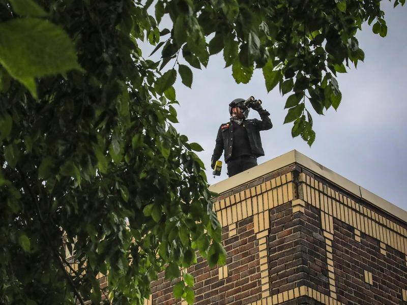 A neighborhood watch member keeps look-out from a roof in Minneapolis.