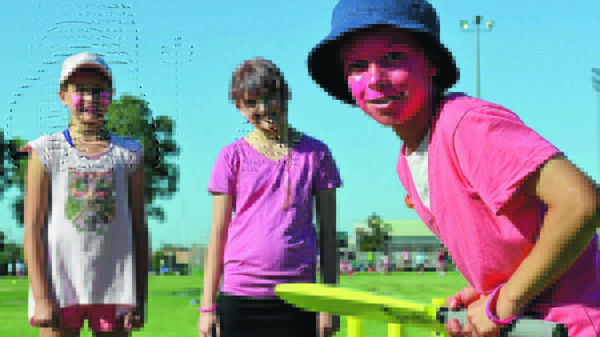 TICKLED PINK: Ruby Bassett gets ready in slip alongside Aimee Taylor at wicket-keeper and batsman Ben Mahlknecht at Griffith East Primary School’s pink stumps day initiative on Friday. 
