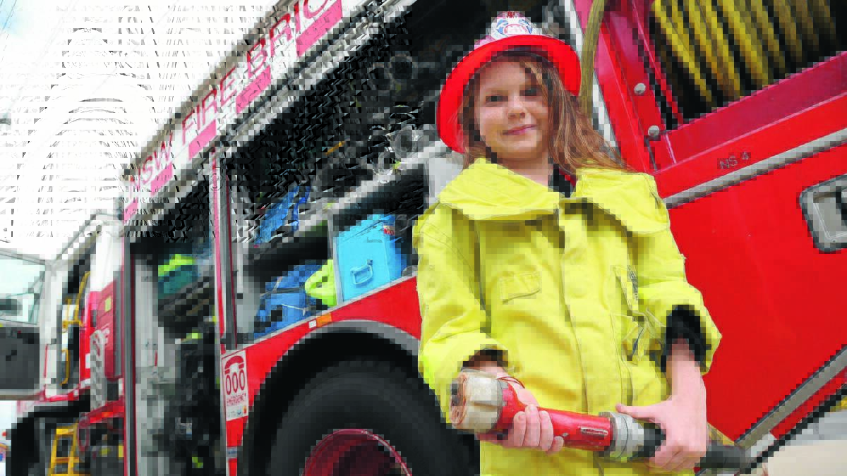 GET A GRIP: Cheyenne Reavley, 8, tries her hand at being a firefighter on Saturday at the Fire and Rescue NSW open day in Griffith. Picture: Anthony Stipo