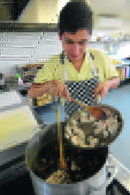 MADE WITH CARE: Wade High School year 10 food technology student Bruno Salvitti stirs the chicken curry being prepared for Griffith’s Care Van. Picture: Anthony Stipo