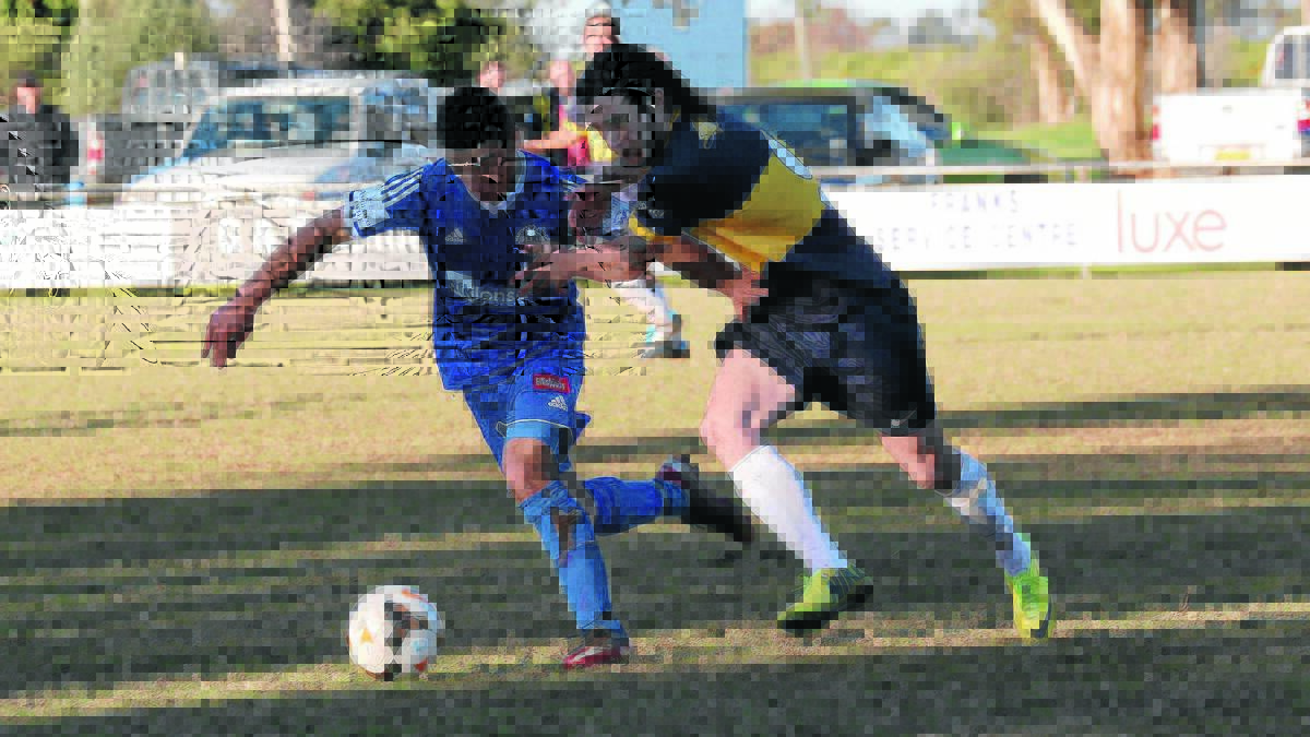FLEET FOOTED: Yoogali SC’s Mitch Bagiante and Hanwood Juniors’ Vincenzo Vasta pin their ears back to hunt down a loose ball at Hanwood Oval yesterday. 