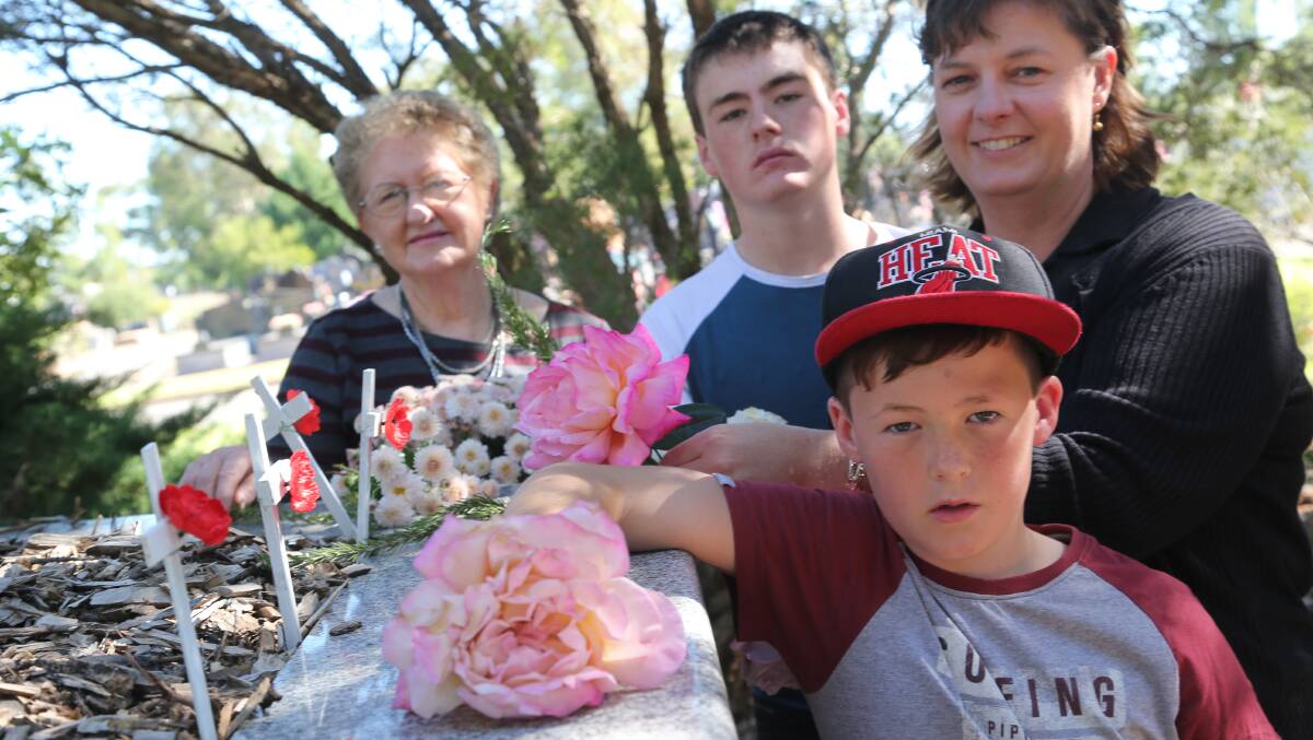Anzac Day 2014, the Burley family Maureen, Reid 14, Kylie and Sam 9, placing a flower on solider's graves.
