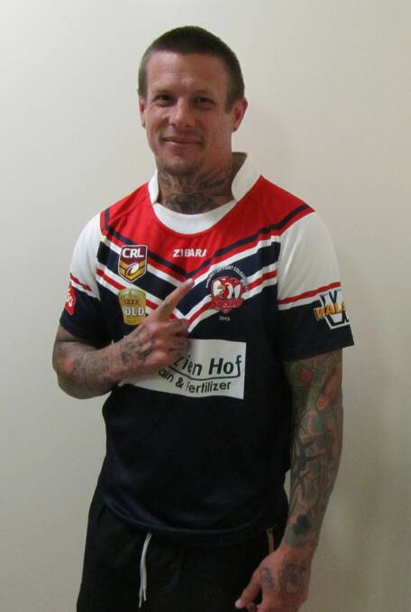 THAT'S GOLD: Ryan McGoldrick tries on his new DPC Roosters jersey ahead of his debut against the Black and Whites this weekend.