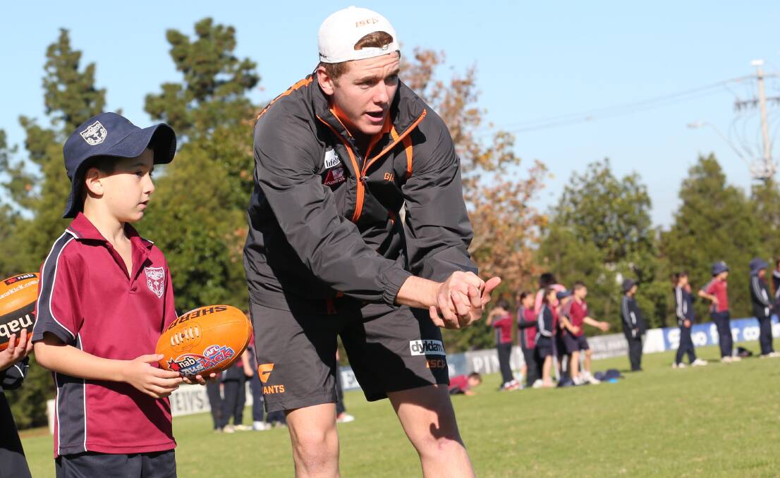 GIANT AMBITION: Leeton-born GWS midfielder Jacob Townsend shows St Mary's student Zackari Ross how it's done during Wednesday's clinic at Exies Oval. Picture: Anthony Stipo