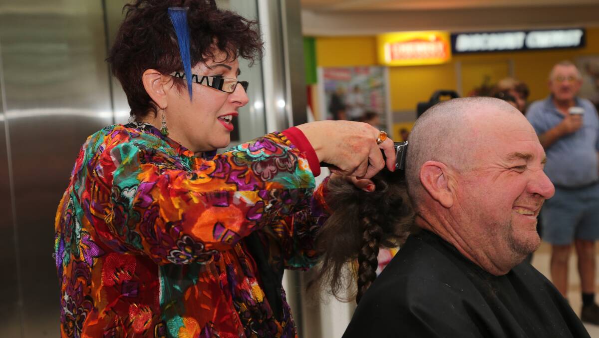 AFTER: Hairdresser Liz Martin uses her clippers to turn Brett Brown from tatty to tidy for a good cause.