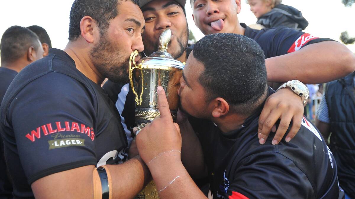 CELEBRATION: Griffith Blacks players kiss the premiership trophy after winning the SIRU grand final.
