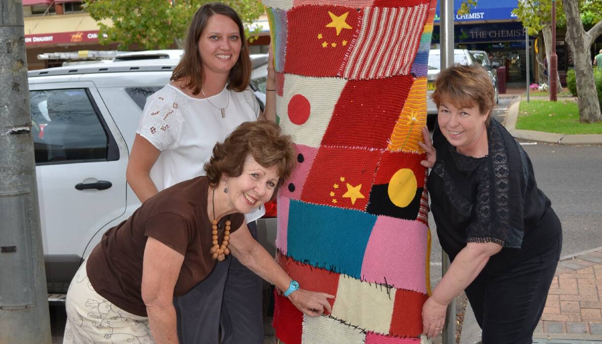 Jo Nathan, Evelyn Garzoli and Donna
Brasington wrap a tree in Griffith’s main street on Saturday
following the Yarn Bombing workshop held at the library.
Picture: Wendy Simpkin