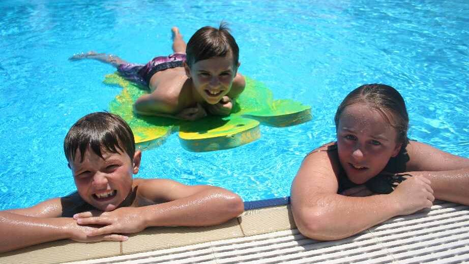 Cooling down at the Junee Rec Centre are Charlie McEwen, 8, Harry McEwen, 11, and Ashleigh Howe, 12. Picture: Declan Rurenga
