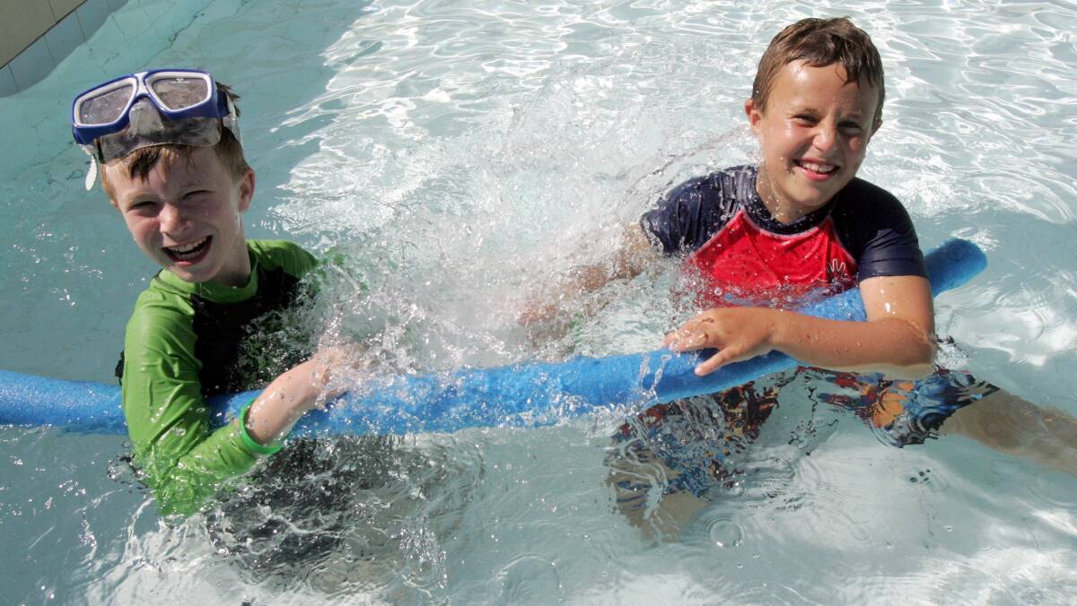Isaac Currie and Calum Dunn, both eight, splash around to cool down in Leeton. Picture: John Gray