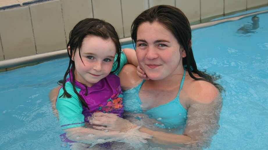 Cooling down at the Junee Rec Centre is Aleesha Shephard, 4, and Jamie Byrne, 11. Picture: Declan Rurenga