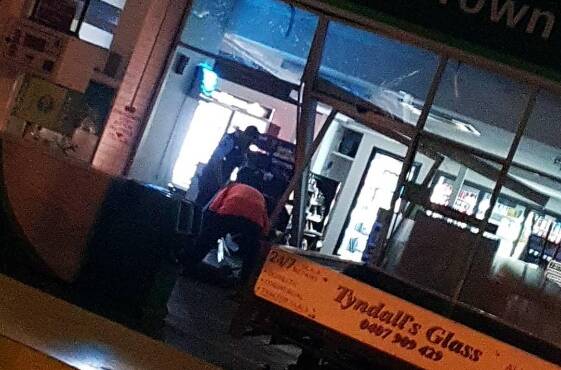 Worker repair the damaged service station shopfront after police set up a crime scene. PHOTO: Nicholas Ralph