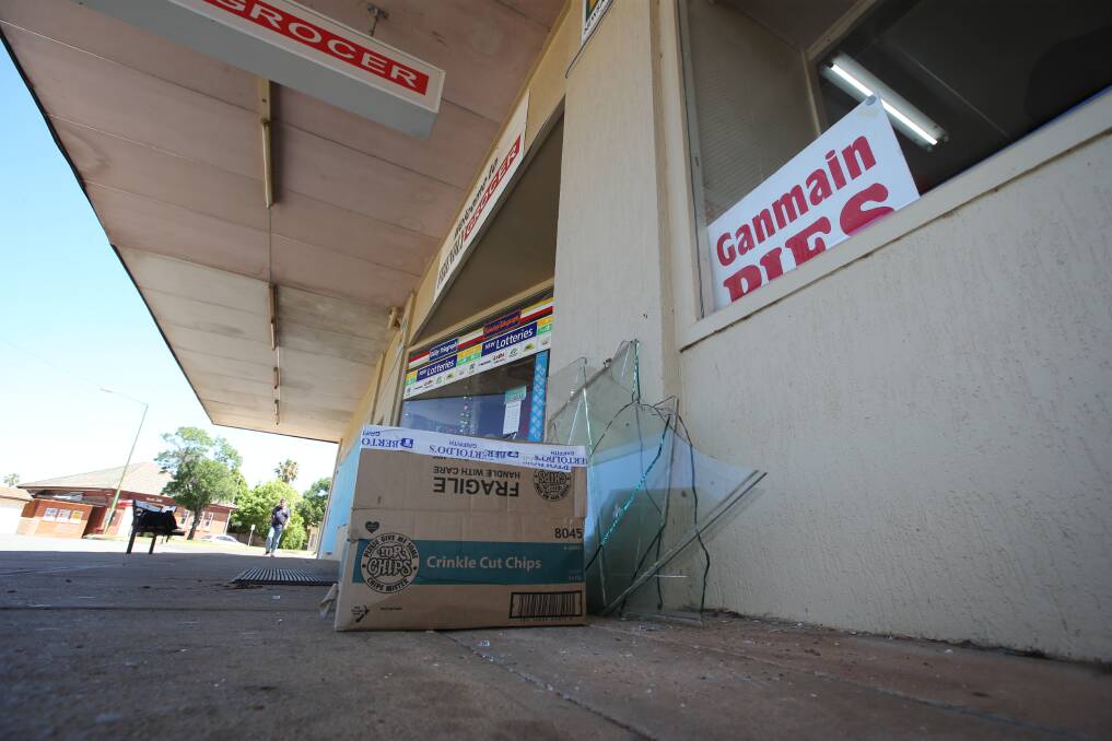 PICKING UP PIECES: Broken glass is gathered for evidence following a break-in at the Yenda Friendly Grocer on Monday. Picture: Anthony Stipo