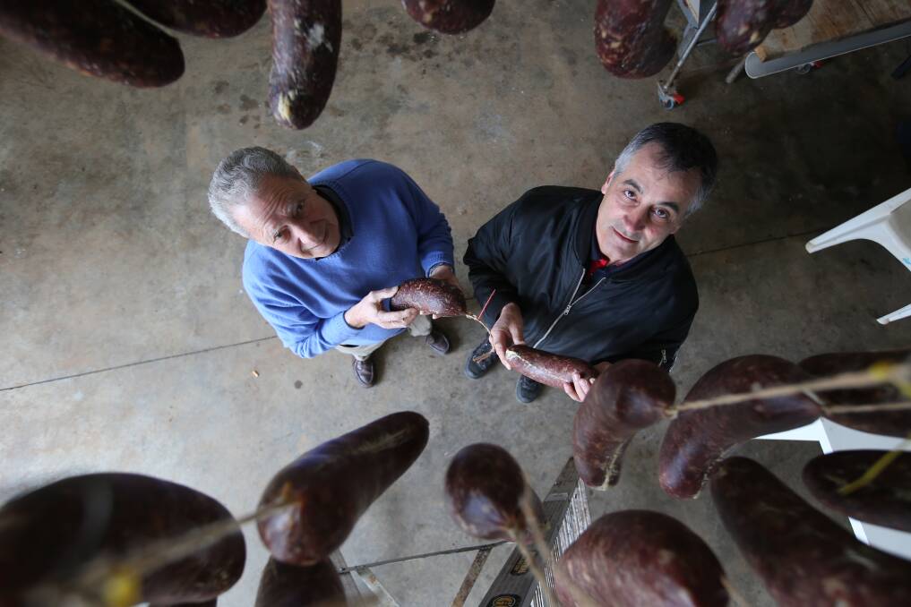 Roy Catanzariti and Nigel Ippoliti examine some hanging salamis. PHOTO: Anthony Stipo