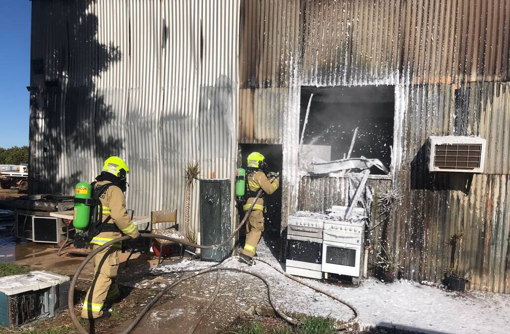 HOT SPOT: Griffith firefighters working to extinguish a blaze inside a farm shed at Nericon on Saturday. PHOTO: Fire and Rescue NSW