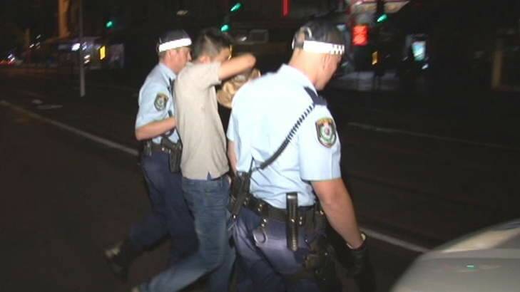A man is escorted away by police after a girl was allegedly set on fire in an apartment in Haymarket last night. Photo: Ten Eyewitness News Photo: Ten Eyewitness News