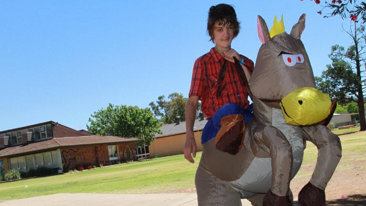 Connor McNab, 12, makes a convincing jockey during Griffith East Public School's Fashions on the Field Picnic Day.